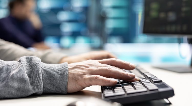 Governmental IT expert monitoring cyber threats on a computer and big screen, high tech agency office. Hackers examining cyber defense measures for prevention of dangerous digital threats.