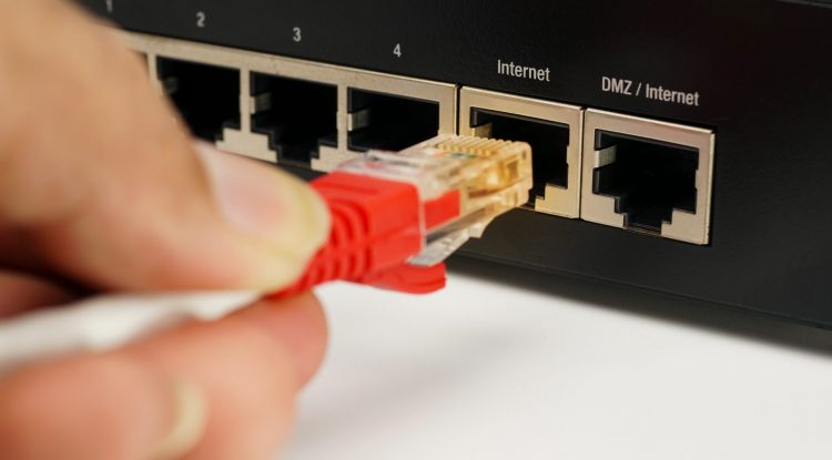 man-plugs-internet-cable-into-routerlan-network-internet-connection-ethernet-rj45-cable